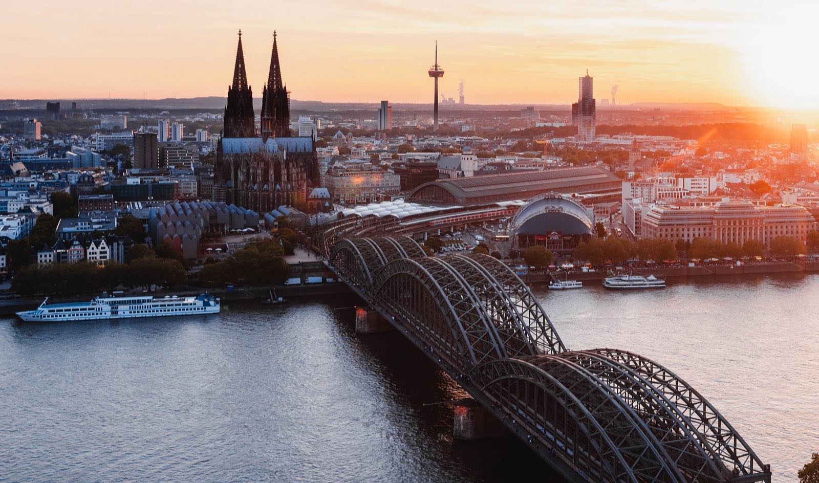 Kölner Dom und Hohenzollernbrücke am Rhein bei Sonnenuntergang